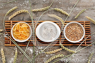 Bowls with wheat flour, grains and pasta on wooden table Stock Photo