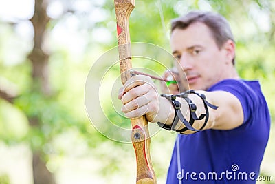 Bowman aiming arrow at target Stock Photo