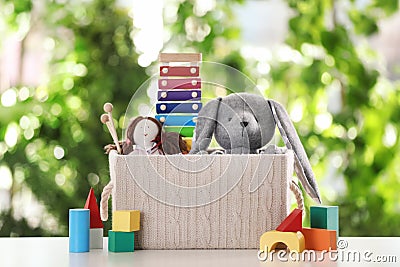 Box and different toys on table Stock Photo