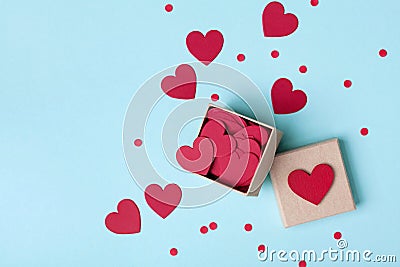 Box full of red hearts and confetti on blue table top view. Valentines day background. Flat lay style. Stock Photo