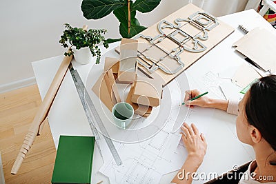 Box maker working behind a table, drawing scematics, tools scattered across Stock Photo