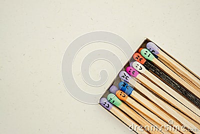 Box with Multicolored matchsticks with faces painted on the heads Stock Photo