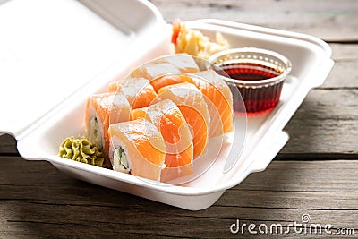 Box with rolls Philadelphia soy sauce and wasabi on a wooden background Stock Photo