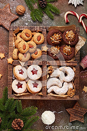 Box with variety of Christmas cookies: linzer cookies with jam, crescents with sugar powder, almond cookies, chocolate cookies Stock Photo