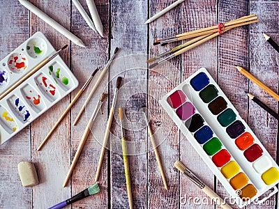 A box of watercolors, a palette, brushes and other items are ready for painting. Stock Photo