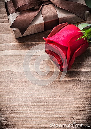 Boxed present expanded rosebud on wooden board Stock Photo