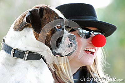 Boxer dog posing for photograph with happy pretty young woman owner Stock Photo