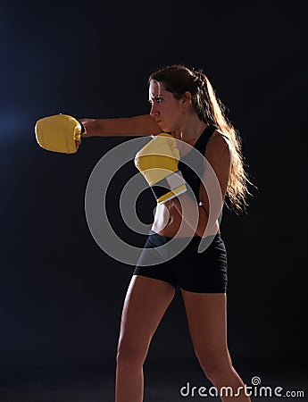 Boxer. Fitness woman wearing yellow boxing gloves Stock Photo