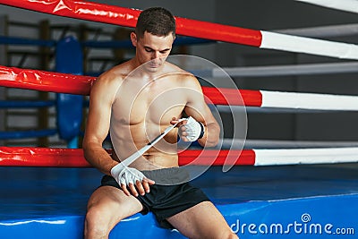 Boxer man is wrapping hands with boxing wraps Stock Photo