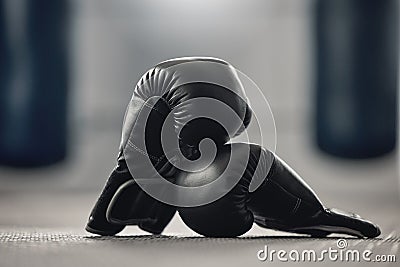 Boxing gloves on the floor of a gym after exercise, training and workout. Pair of sport handwear or equipment on the Stock Photo