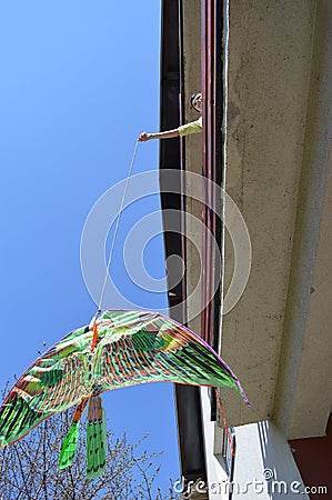 boy in the age of the corona virus releases a dragon on the terrace Stock Photo