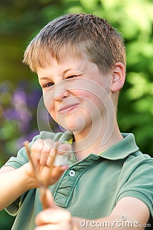 Boy Aiming Slingshot In Garden Stock Photo