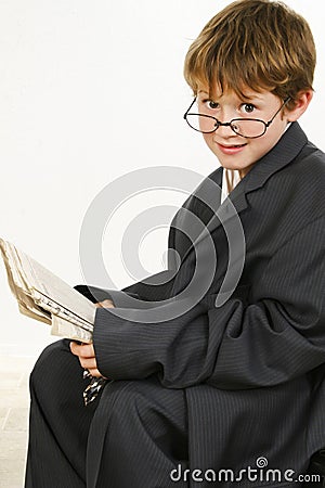 Boy in Baggy Suit Reading Newspaper Stock Photo