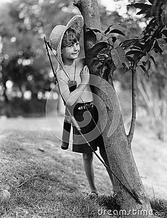 Boy behind tree with bow and arrow Stock Photo
