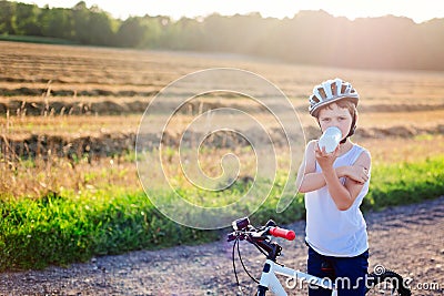 Boy in a bicycle helmet drinks bottled water Stock Photo