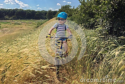 Boy on bike in field Stock Photo