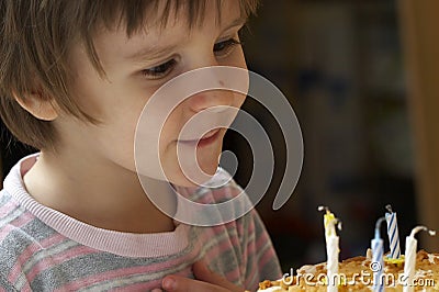 Boy blow out celebratory candles Stock Photo