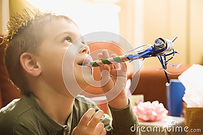 Boy blowing noisemaker. Stock Photo