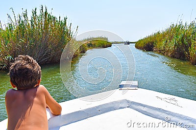 Boy on the boat, advancing in the river Stock Photo