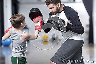 Boy boxer practicing punches with coach Stock Photo