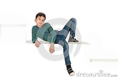 The boy brunette wearing in jeans and shirt in green strip sits Stock Photo