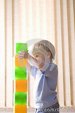 Boy Building Colorful Bricks At Home Stock Photo