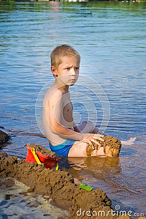 Boy builds a sand Stock Photo