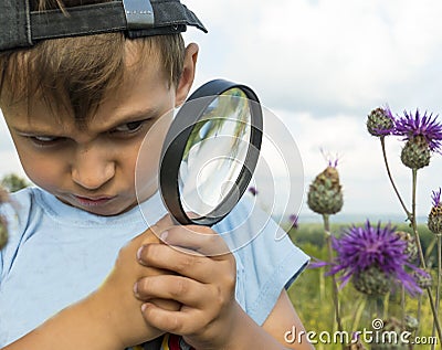 Harsh young naturalist with a magnifier Stock Photo