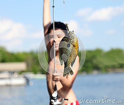 Boy catching a fish in Michigan lake during summer, fishing activity with family. Fun child. Stock Photo