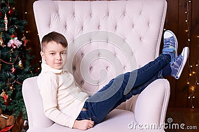 Boy on chair. Christmas interior. Brown background. Horizontally Stock Photo