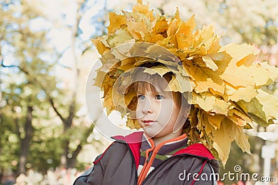 Boy with chaplet of yellow maple leaves Stock Photo