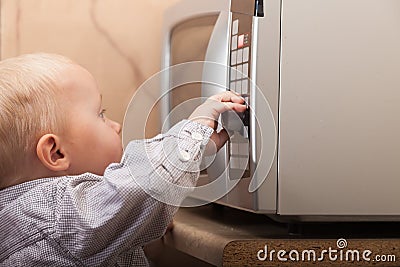 Boy child kid playing with timer of microwave oven Stock Photo