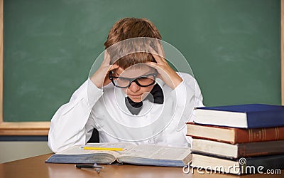 Boy child, stress and thinking with books, classroom and anxiety for exam, assessment and studying for knowledge Stock Photo