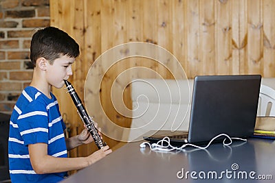 Boy with a clarinet plays music. Online music lesson concept Stock Photo