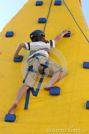 Boy climbing a climbing wall. Stock Photo