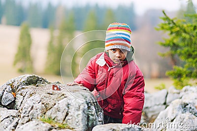 Boy climbing on mountain rocks Stock Photo