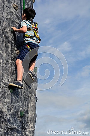 Boy Climbing Wall Outdoors Stock Photo