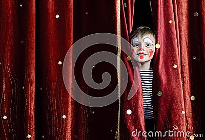 Boy Clown Peering Through Stage Curtains Stock Photo