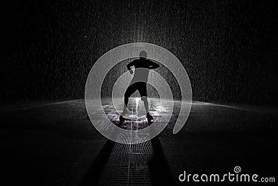 Boy dancing in the rain silhouette in artistic black and white. Stock Photo