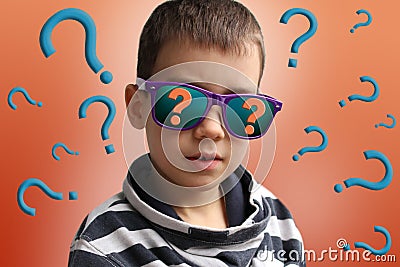 Boy in dark sunglasses, the reflection of which depicts a question mark, in a striped sweater, surrounded by many question marks, Stock Photo