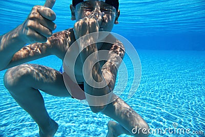 Boy dives under water in pool Stock Photo