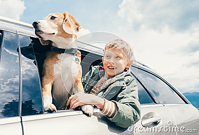 Boy and dog look out from car window Stock Photo