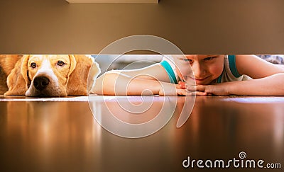 Boy with doggy friend looks under the bed Stock Photo