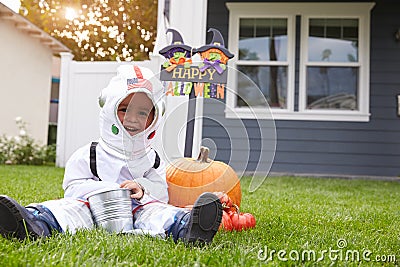 Boy Dressed In Trick Or Treating Spaceman Costume On Lawn Stock Photo