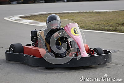 Boy is driving Go-kart car with speed in a playground racing track. Stock Photo