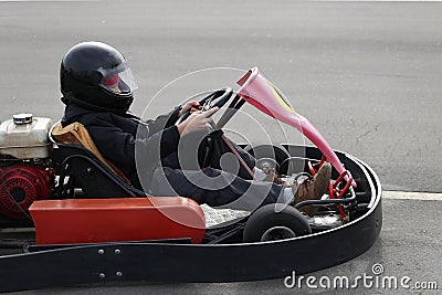 Boy is driving Go-kart car with speed in a playground racing track. Stock Photo