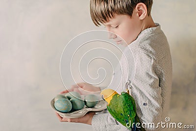 Boy with Easter eggs and a parrot Stock Photo