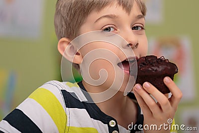 Boy eating caloric muffin Stock Photo