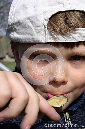 Boy Eating Honey Stock Photo
