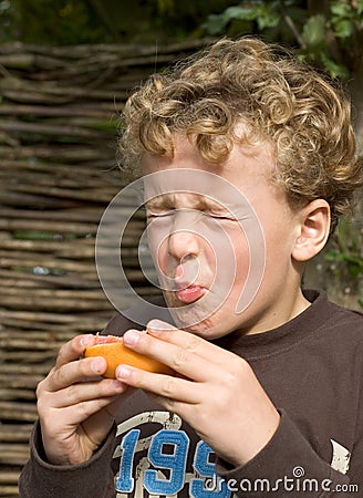 Boy eating Sour Fruit Stock Photo